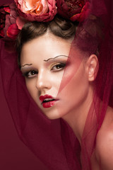 Beautiful girl with art creative make-up in the image of a red bride for Halloween. Beauty face. Photo taken in studio