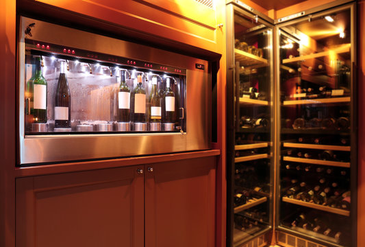 Dispenser and refrigerators with bottles of wine in cellar