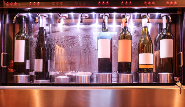 Dispenser with opened bottles of wine in cellar, closeup