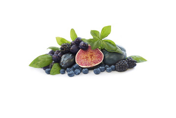 Group of fresh fruits and berries with basil's on a white background. Ripe blueberries, blackberries, grapes, plums and figs. Blue and purple food. Fruits with copy space for text.