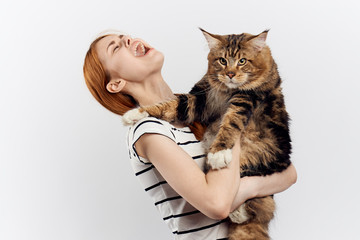 Young beautiful woman on white isolated background holds a cat, an allergy