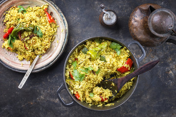 Indian Vegetable Biryani with Sweet Pepers and Zucchini as close-up in a frying pan
