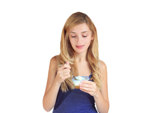 Young caucasian woman eating yogurt isolated on white