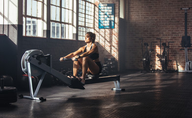 Young woman exercising in gymnasium.