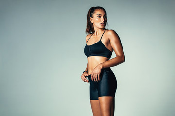 Fototapeta na wymiar Fitness woman in sportswear standing over grey background