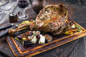 Barbecue Leg of Lamb with Vegetables and Feta as top view on cutting board