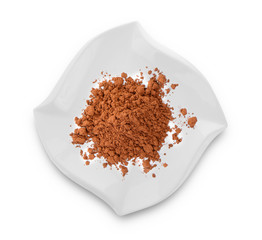 Cocoa powder in modern ceramic plate on white background