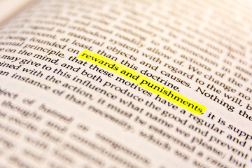 Fototapeta premium Book Highlighted Word Yellow Fluorescent Marker Paper Old Keyword Rewards and Punishments