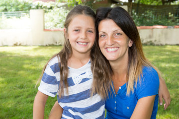 two girls mother and pretty daughter smiling outdoors