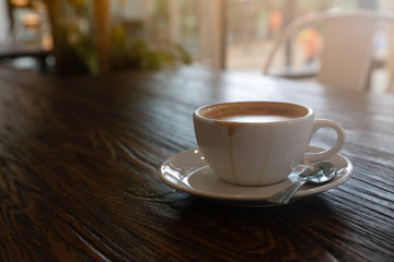 Hot coffee on wooden table and light sunshine in the morning