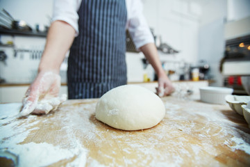 Raw loaf of bread on wooden board