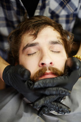 Fototapeta na wymiar Relaxed client enjoying massage of his face