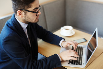 Businessman concentrating upon networking or reading online data