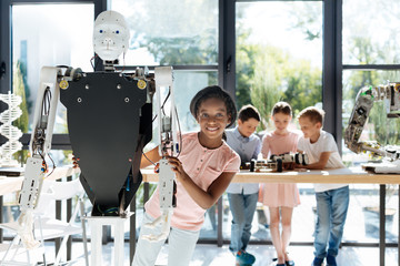 Pleasant girl looking out from behind a human robot