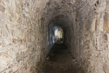 Looking into a dark corridor of the Citadel of Namur. At the end is the reflection of light coming through loopholes which are not visible