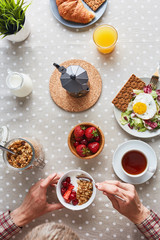 Man eating healthy breakfast by served table