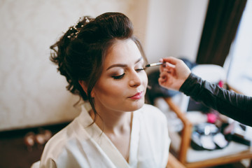 Morning make-up in the room for a beautiful bride