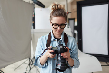 Fototapeta na wymiar Woman with photocamera working in studio