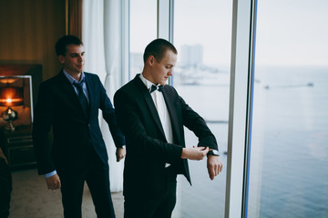 Friend helps the groom to dress in the morning