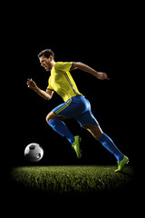 Professional football soccer player in action isolated on black