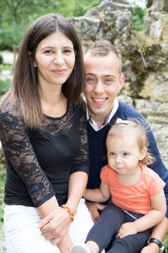 Happy family with pumpkin on autumn leaves