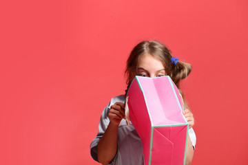 School girl with package isolated on salmon red background