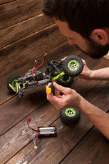 Rc radio control car crawler model toy chassis repair. Green toy suv in repairshop workplace, free space