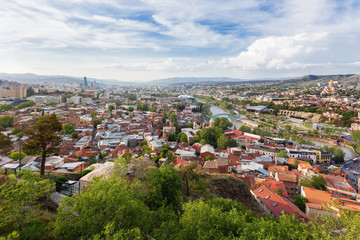 Panorama view of Tbilisi, capital of Georgia country. View from Narikala fortress. Cable road above tiled roofs.