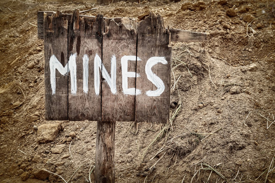 Wooden weathered warning sign for mines