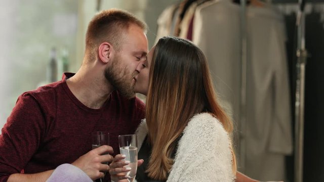 Young couple kissing and drinking champagne