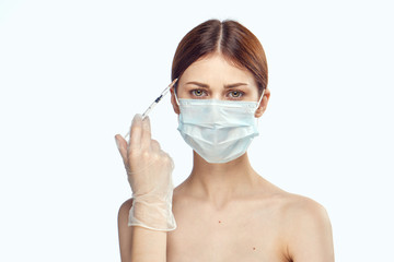 Young beautiful woman on white isolated background holds a syringe, plastic surgery, medicine