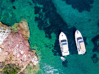 Aerial view of two yachts and clear turquoise sea