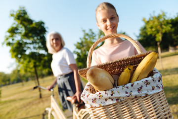 Positive teenager girl holding a basket for a picnic