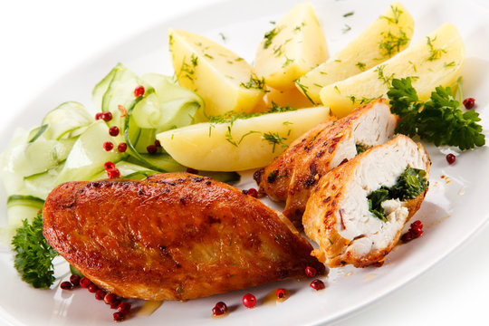 Stuffed chicken fillets and vegetables on white background