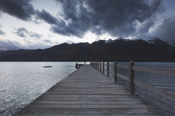 A traveler standing at the end of wooden pier. 