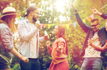 Fototapeta premium happy friends dancing at summer party in garden