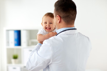 happy doctor or pediatrician with baby at clinic