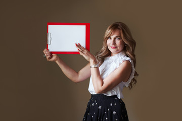 Beautiful middle age woman with empty clipboard with blank space