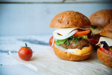 The traditional hamburger Patty, cheese, tomato, lettuce, beef Burger, takeaway. Dark wooden background, horizontal shot.