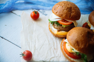 The traditional hamburger Patty, cheese, tomato, lettuce, beef Burger, takeaway. Dark wooden background, horizontal shot.