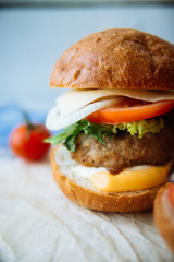 Tasty turkey burgers with corn salad and carrot,mixed seeds served on old board on a rustic wooden table with copyspace.