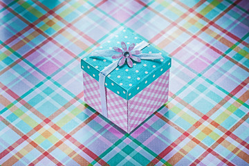 Wrapped present box on checked fabric background celebrations co