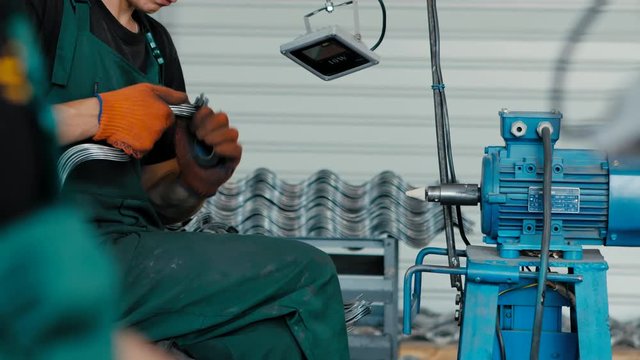 Metal grinding on bench grinder with flying sparks