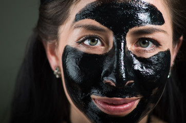 Close up of a beauty young woman using a black mask to clean skin
