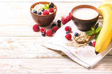 Raspberry, blackberry and blueberry, oatmeal breakfast with milk