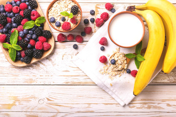 Raspberry, blackberry and blueberry, oatmeal breakfast with milk