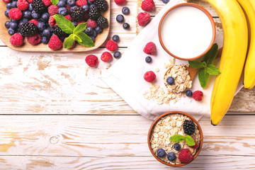 Raspberry, blackberry and blueberry, oatmeal breakfast with milk