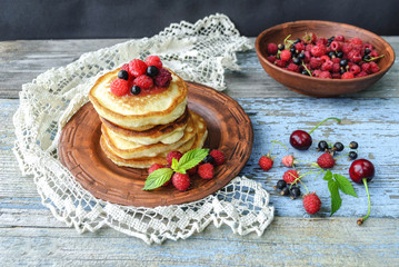 Plate with delicious pancakes and berries on table
