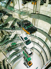 Many cars suspended on a steel cable in the car sales center. The construction of cars in the center of the auto store.