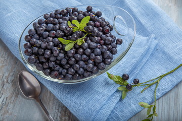 Fresh forest berry, blueberries in a glass plate on a wooden table